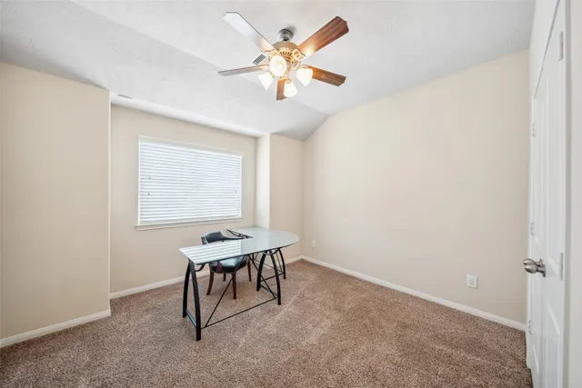 a room with chandelier fan and windows