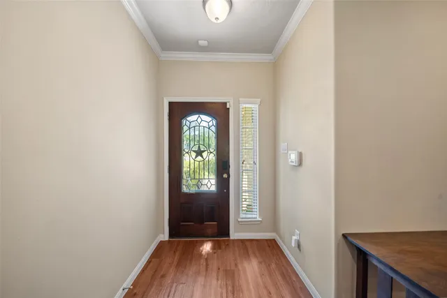a view of a hallway with wooden floor and a kitchen