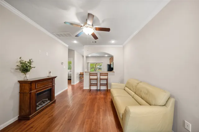 a living room with furniture and a wooden floor