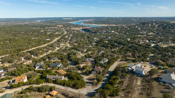 an aerial view of residential houses with outdoor space and trees