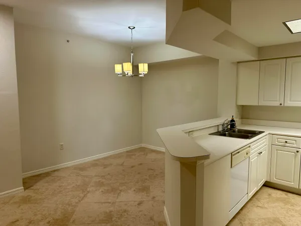 a view of a kitchen with a sink stainless steel appliances and chandelier