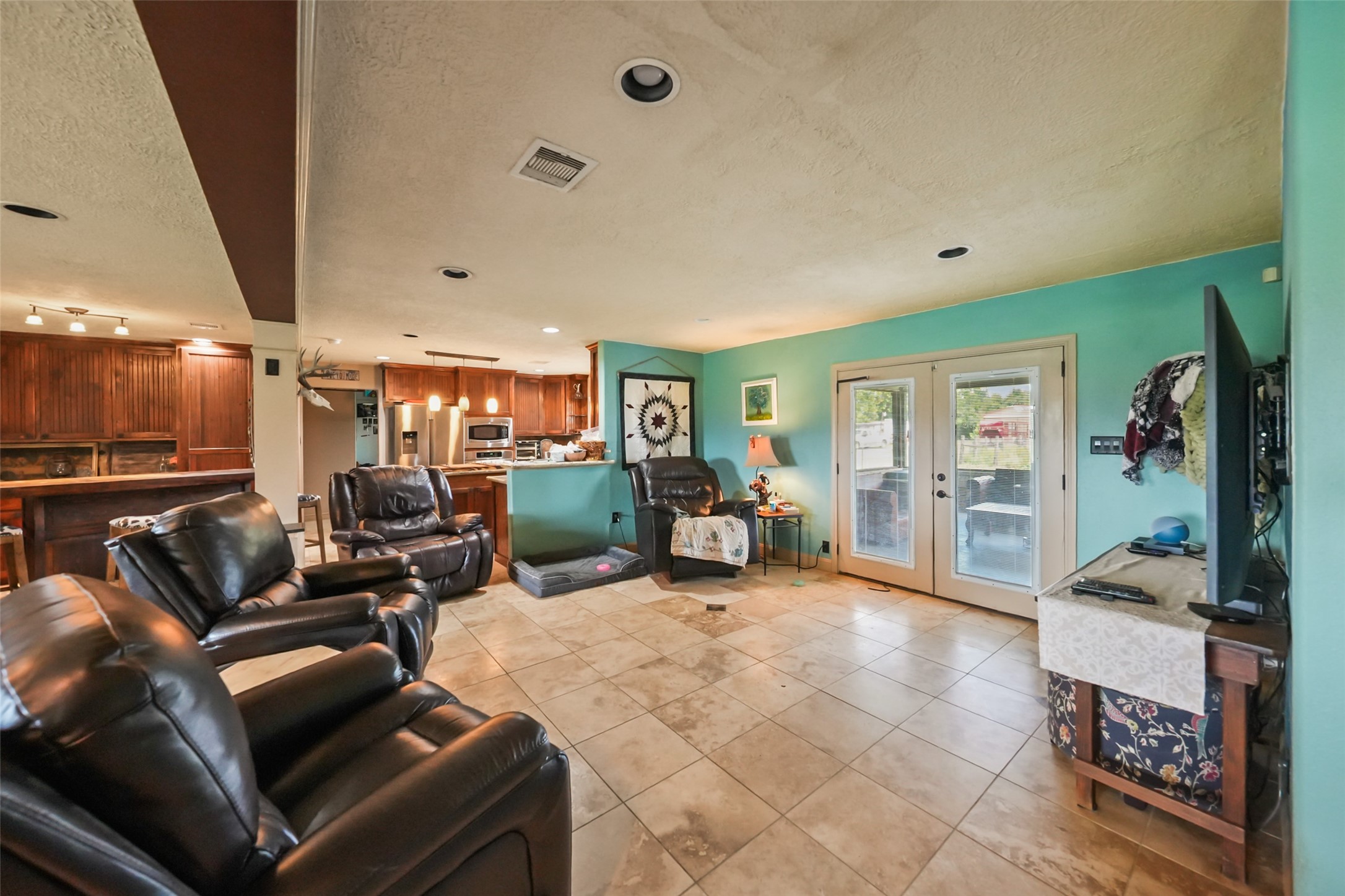 34366 Owens Road Hempstead, TX 77445 - Photo 10 of 46 Spacious living area with an open layout, tile flooring, abundant natural light, and a cozy fireplace that creates a comfortable gathering space.