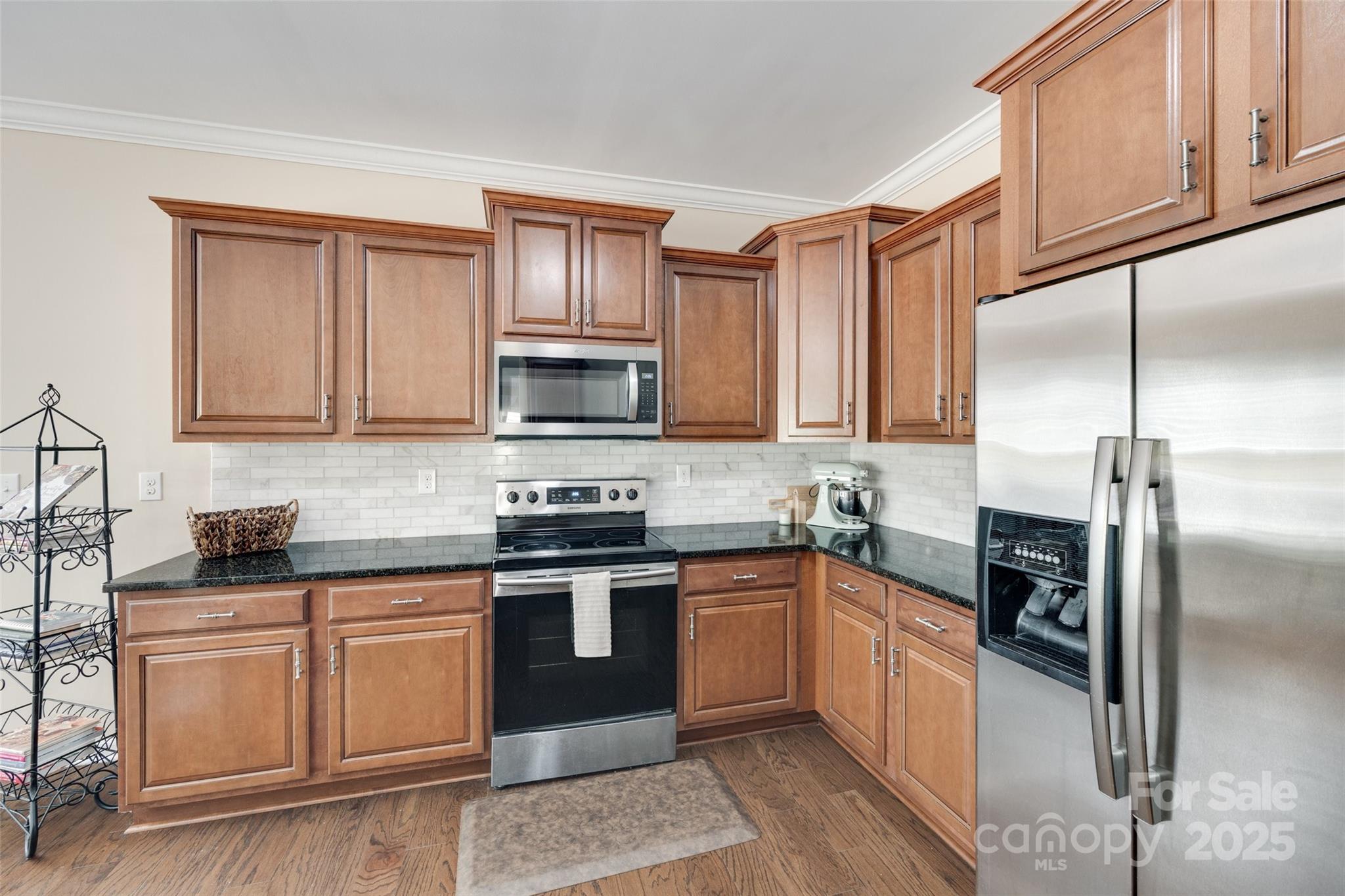 985 Angelica Lane Tega Cay, SC 29708 - Photo 18 of 47 a kitchen with stainless steel appliances granite countertop a stove a sink dishwasher a refrigerator and cabinets with wooden floor