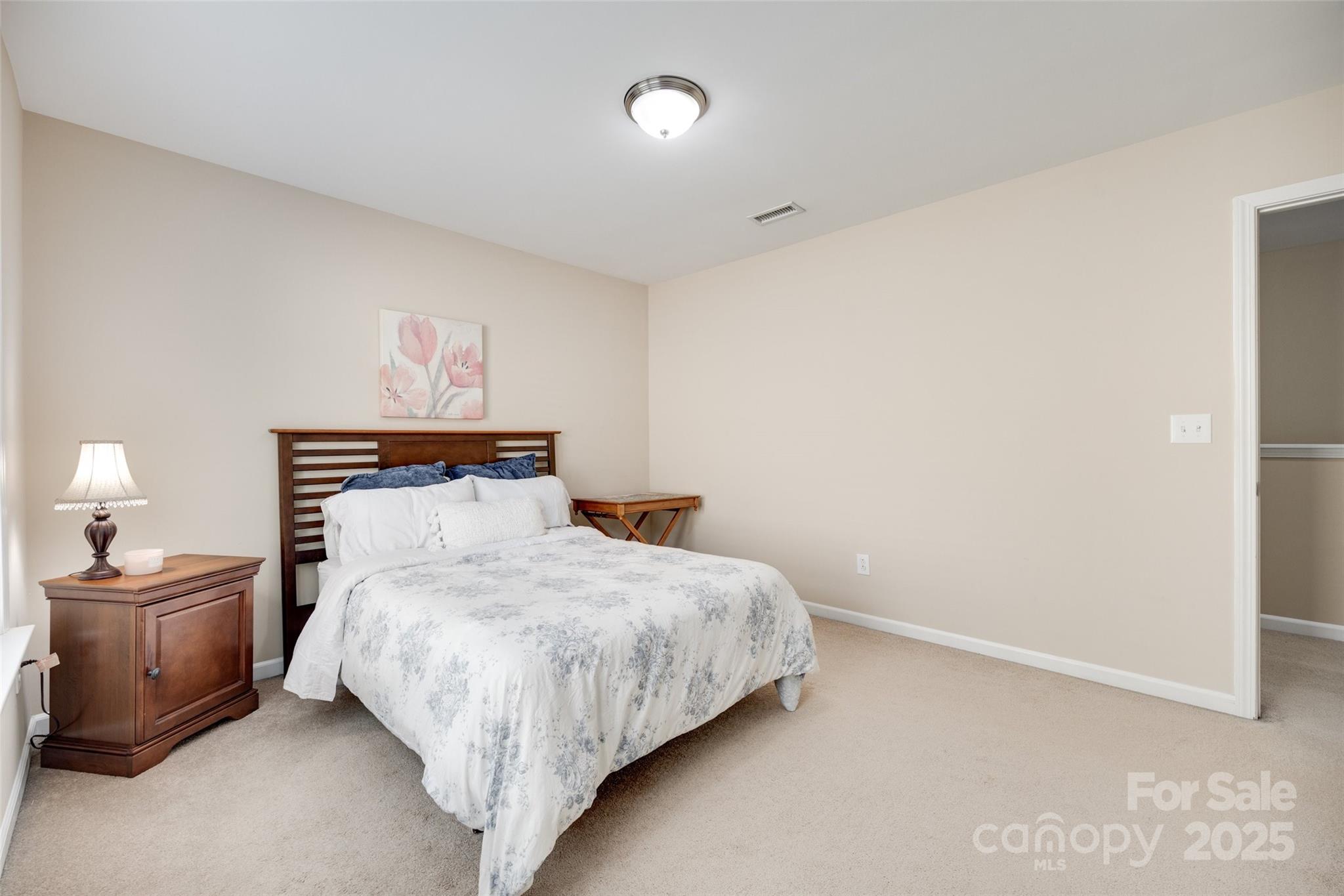 985 Angelica Lane Tega Cay, SC 29708 - Photo 24 of 47 a bedroom with a bed and a lamp on dresser