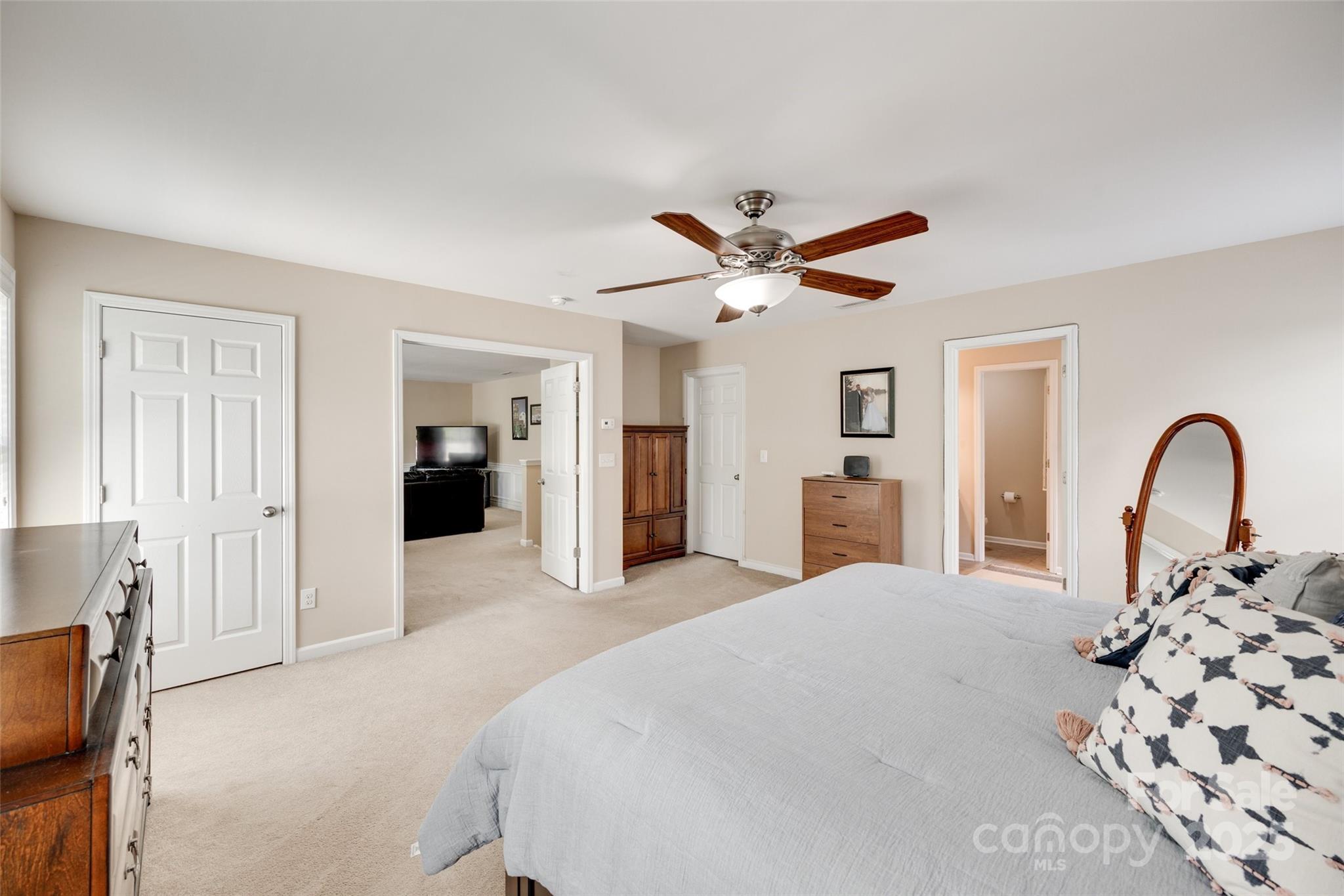 985 Angelica Lane Tega Cay, SC 29708 - Photo 31 of 47 a bedroom with a large bed and a chandelier