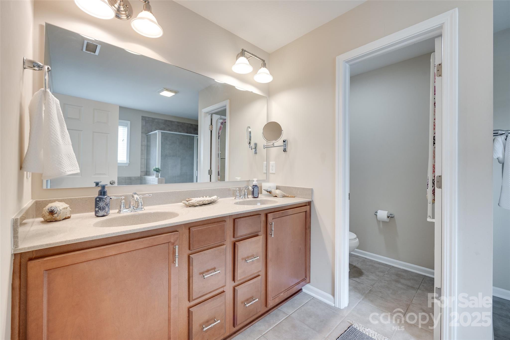 985 Angelica Lane Tega Cay, SC 29708 - Photo 32 of 47 a bathroom with a double vanity sink and a mirror