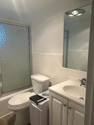 a white toilet sitting next to a bathroom sink and a shower