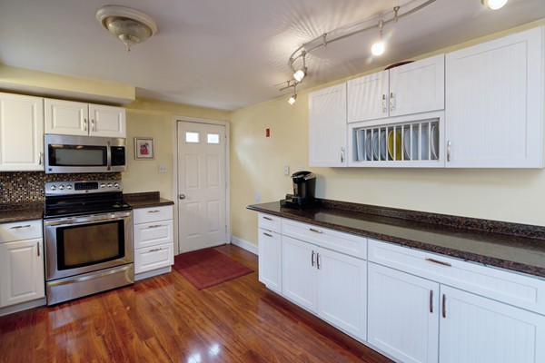 486 Cotuit Road Mashpee, MA 02649 - Photo 11 of 29 a kitchen with granite countertop white cabinets stainless steel appliances and a sink