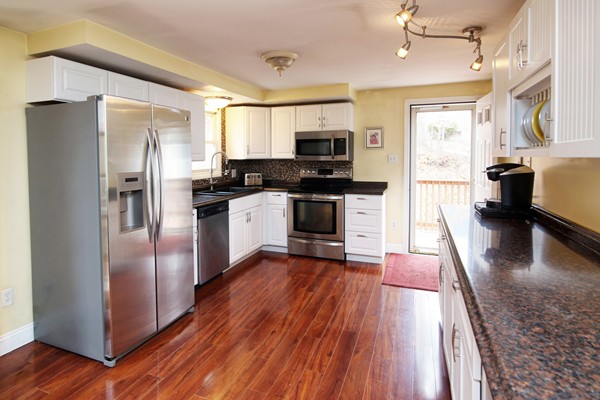 486 Cotuit Road Mashpee, MA 02649 - Photo 8 of 29 a kitchen with stainless steel appliances granite countertop a refrigerator a stove top oven a sink dishwasher and wooden floor