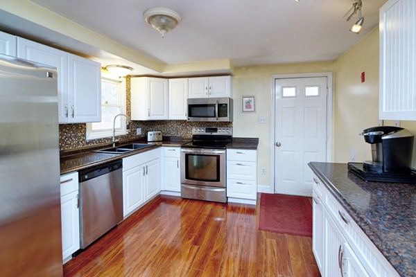486 Cotuit Road Mashpee, MA 02649 - Photo 9 of 29 a kitchen with granite countertop a stove top oven a sink dishwasher and a refrigerator with wooden floor
