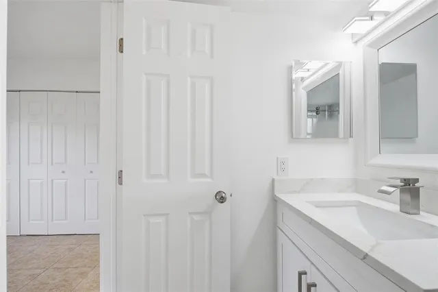 a bathroom with a sink vanity and a mirror