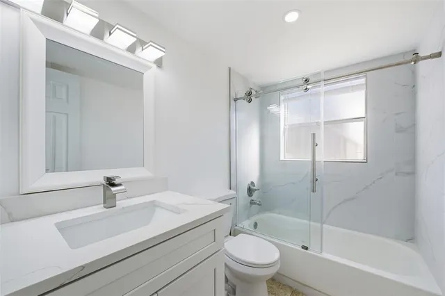 a bathroom with a sink toilet a mirror and shower