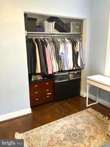 a view of walk in closet with clothes and shoes