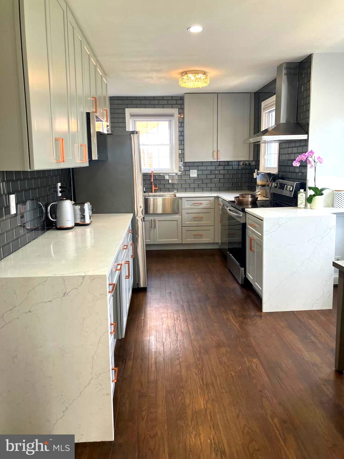 626 South Irving Street Arlington, VA 22204 - Photo 2 of 28 a kitchen with a sink a stove cabinets and a wooden floor