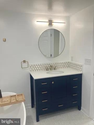 a bathroom with a granite countertop sink a mirror and vanity