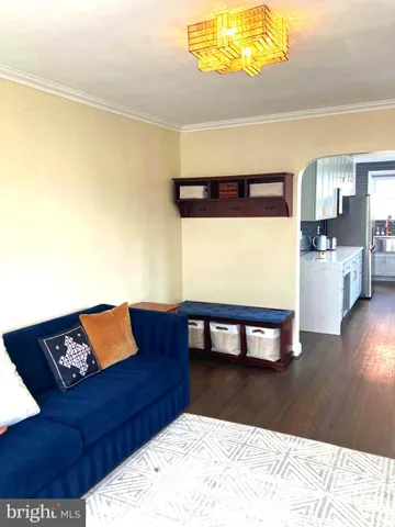a living room with a couch and a dining table with wooden floor