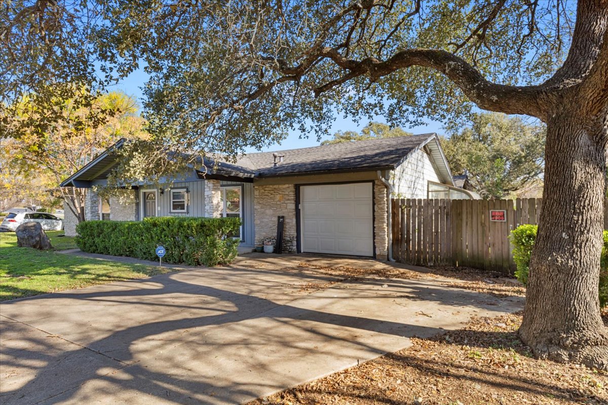8713 Azalea Trail Austin, TX 78759 - Photo 3 of 13 A welcoming facade features a single-car garage and a well-kept hedge lining the front.