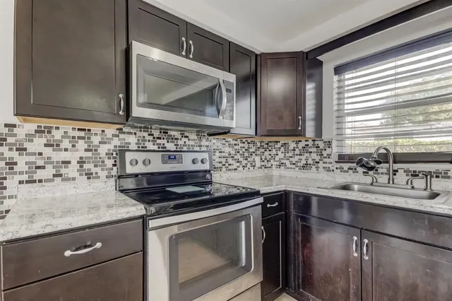 a kitchen with a sink stove and microwave