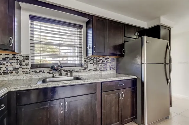 a kitchen with a sink a refrigerator and cabinets