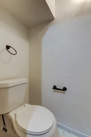 a white toilet sitting next to a shower