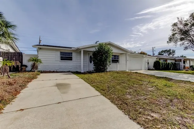 a front view of house with yard and trees around