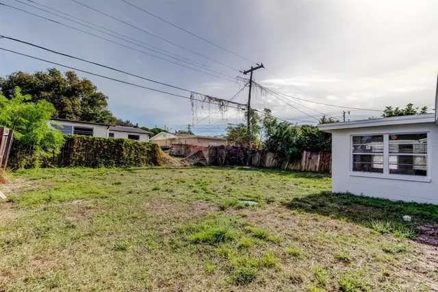 a view of a house with a yard and potted plants