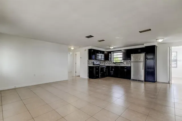 a large kitchen with stainless steel appliances a refrigerator and a stove top oven