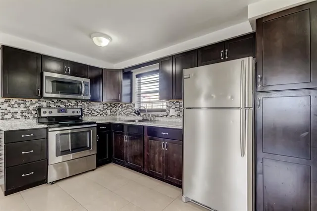 a kitchen with stainless steel appliances granite countertop a refrigerator and a stove top oven