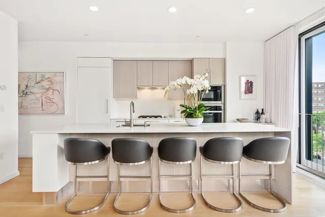 a kitchen with a sink and chairs