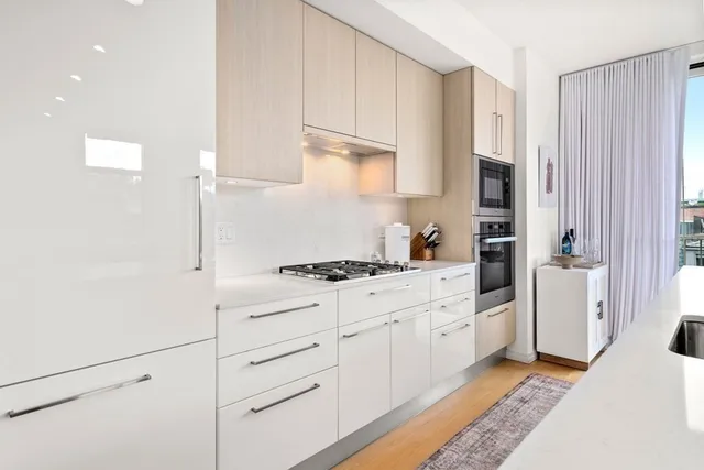 a kitchen with white cabinets and white appliances