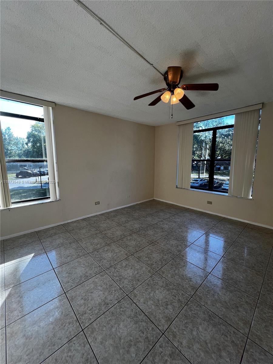 3760 Inverrary Drive, Unit 2Z Lauderhill, FL 33319 - Photo 12 of 34 a view of an empty room with window and chandelier fan
