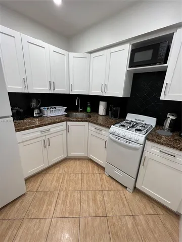 a kitchen with a sink a stove and cabinets