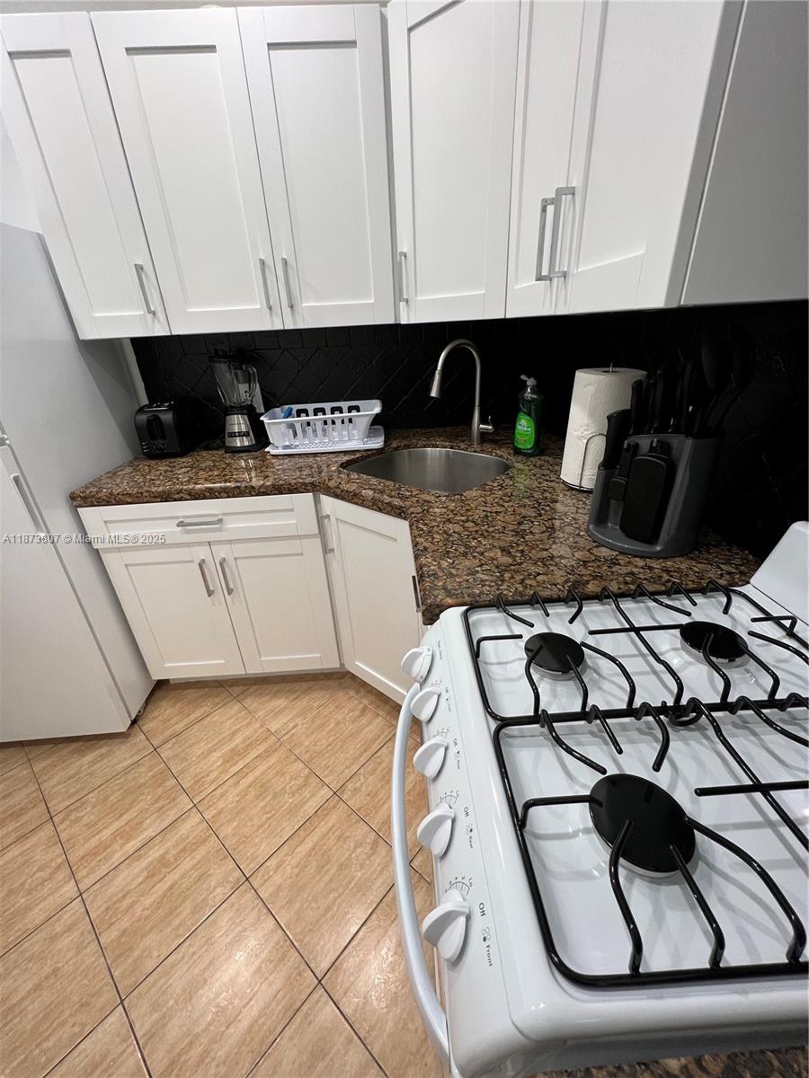 620 Jefferson Avenue, Unit 2 Miami Beach, FL 33139 - Photo 13 of 24 a kitchen with a sink a stove and cabinets