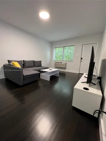 a living room with furniture and a pool table