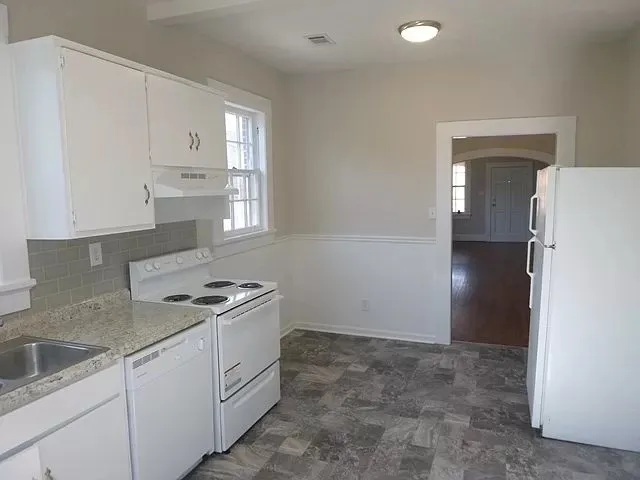 a kitchen with white cabinets and white appliances