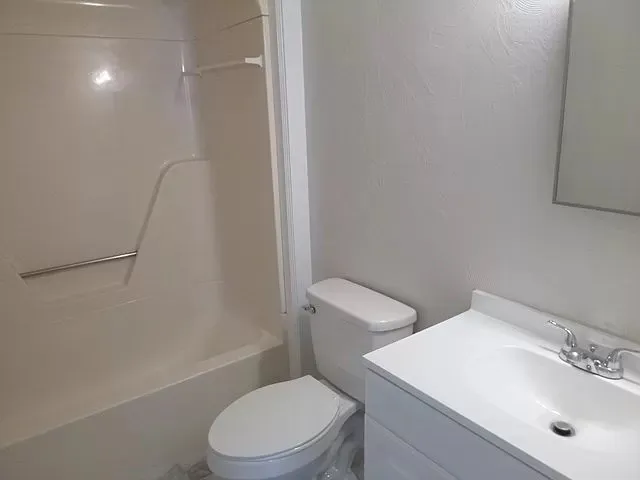 a white toilet sitting next to a bathroom sink