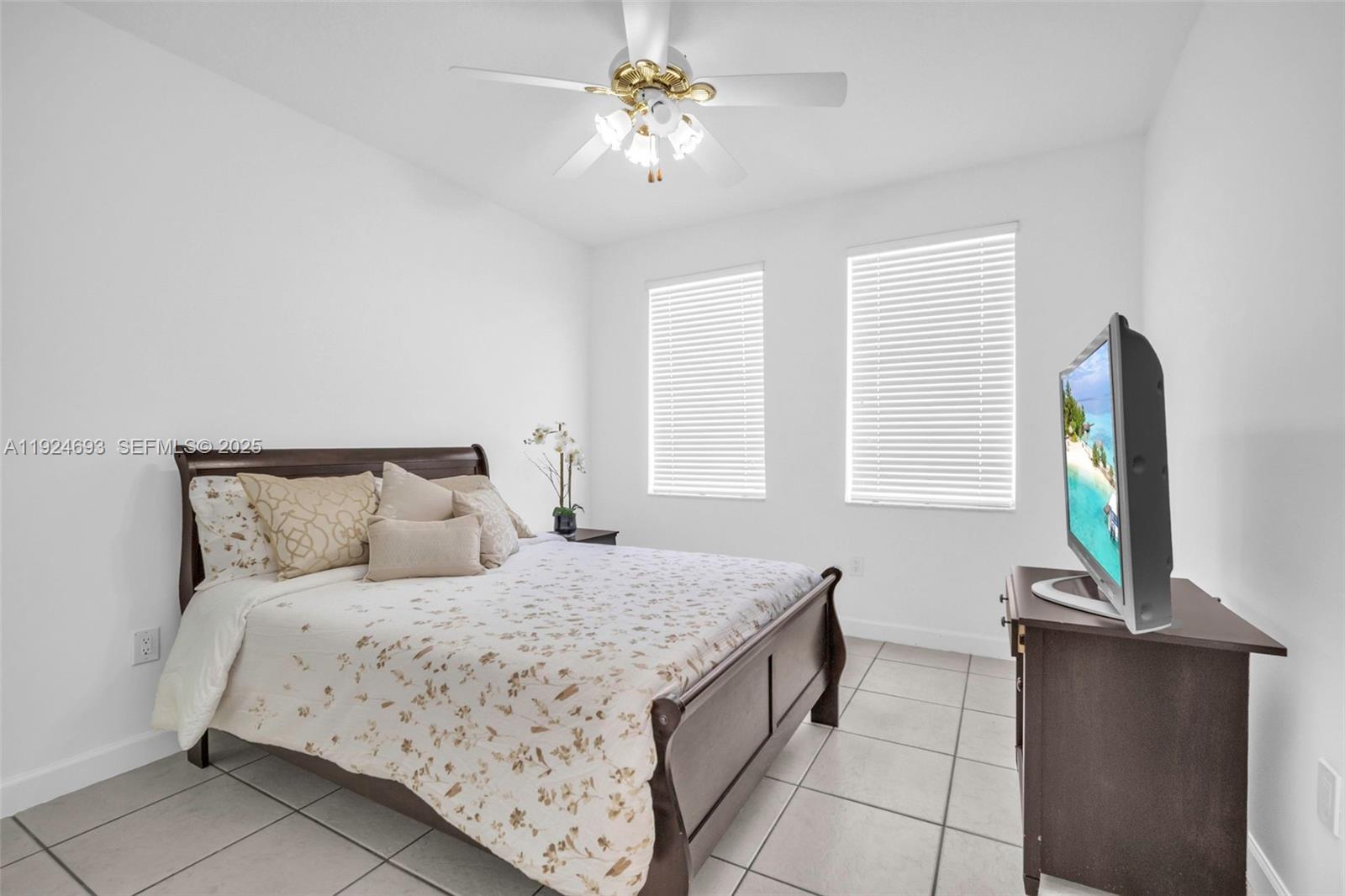 13030 Northwest 8th Street Miami, FL 33182 - Photo 11 of 54 a bedroom with a bed and a flat tv screen on a dresser