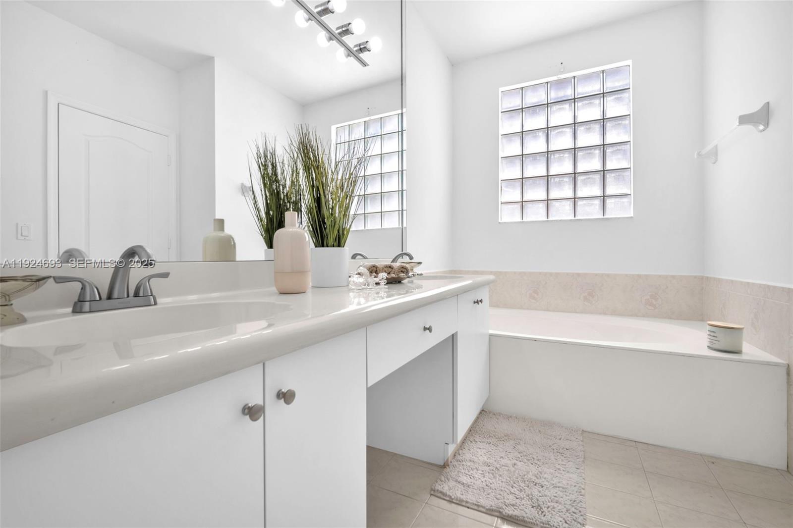 13030 Northwest 8th Street Miami, FL 33182 - Photo 23 of 54 a bathroom with a double vanity sink window and a bathtub