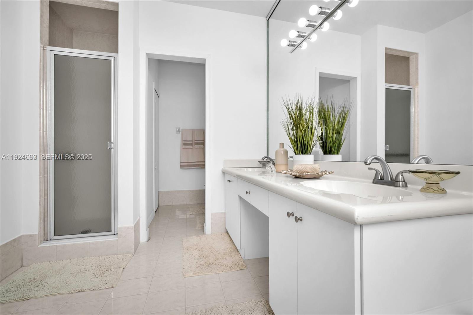 13030 Northwest 8th Street Miami, FL 33182 - Photo 24 of 54 a bathroom with a double vanity sink a mirror and a shower