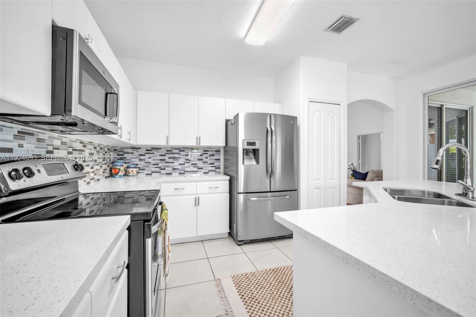 13030 Northwest 8th Street Miami, FL 33182 - Photo 30 of 54 a kitchen with a refrigerator sink and stove