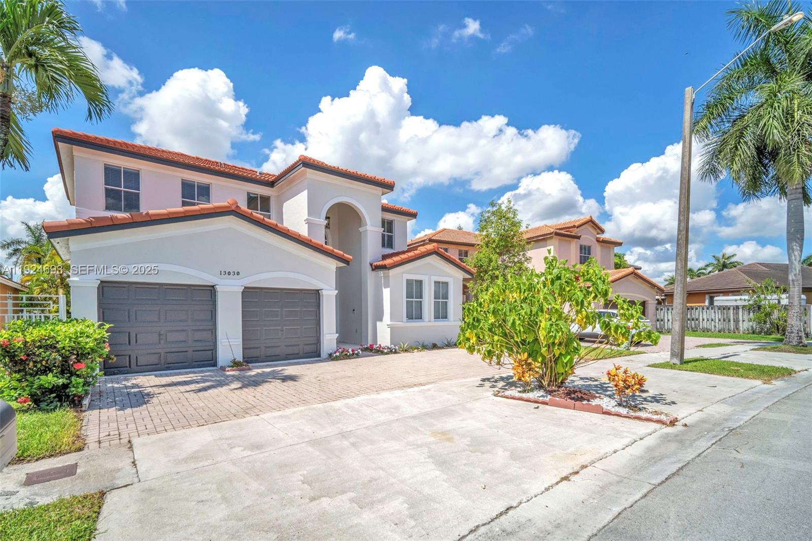 13030 Northwest 8th Street Miami, FL 33182 - Photo 4 of 54 a front view of a house with a yard and garage