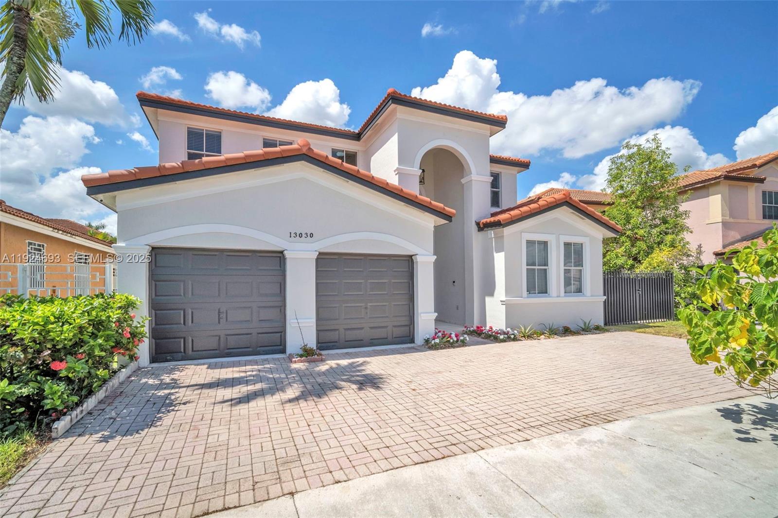 13030 Northwest 8th Street Miami, FL 33182 - Photo 10 of 54 a front view of a house with a yard and garage