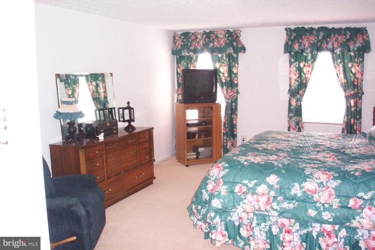 6431 St Phillips Road Linthicum Heights, MD 21090 - Photo 14 of 24 a bedroom with a bed and a chandelier