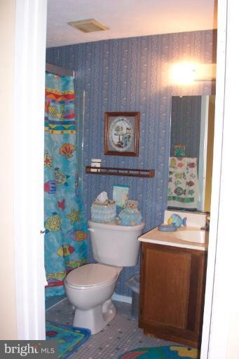 6431 St Phillips Road Linthicum Heights, MD 21090 - Photo 20 of 24 a bathroom with a toilet a sink and a mirror