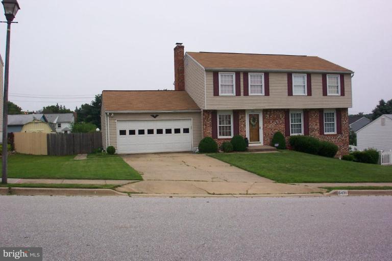 6431 St Phillips Road Linthicum Heights, MD 21090 - Photo 21 of 24 a view of a white house with a yard and a large parking space