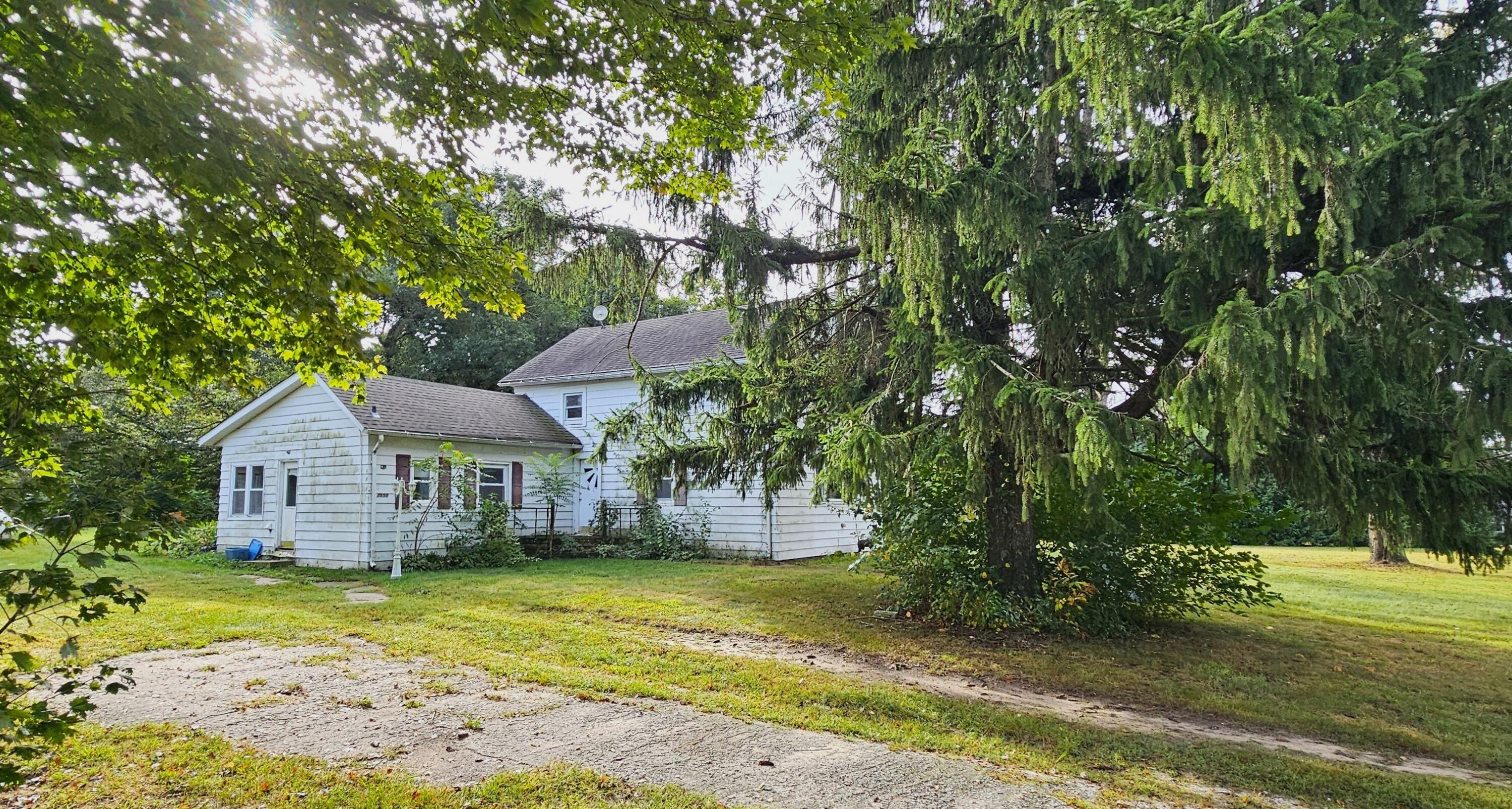 7555 South Sand Road Union Mills, IN 46382 - Photo 1 of 16 a front view of a house with a garden