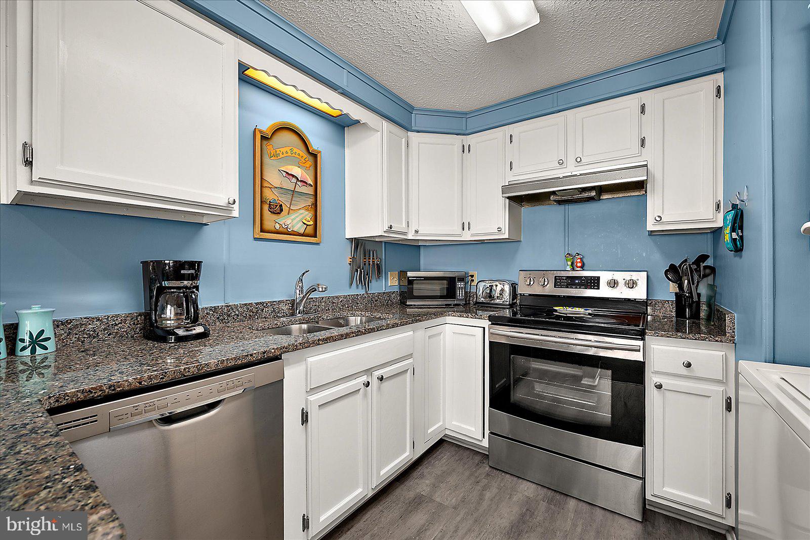 9 46th Street, Unit 22 Ocean City, MD 21842 - Photo 13 of 43 a kitchen with granite countertop white cabinets and white appliances