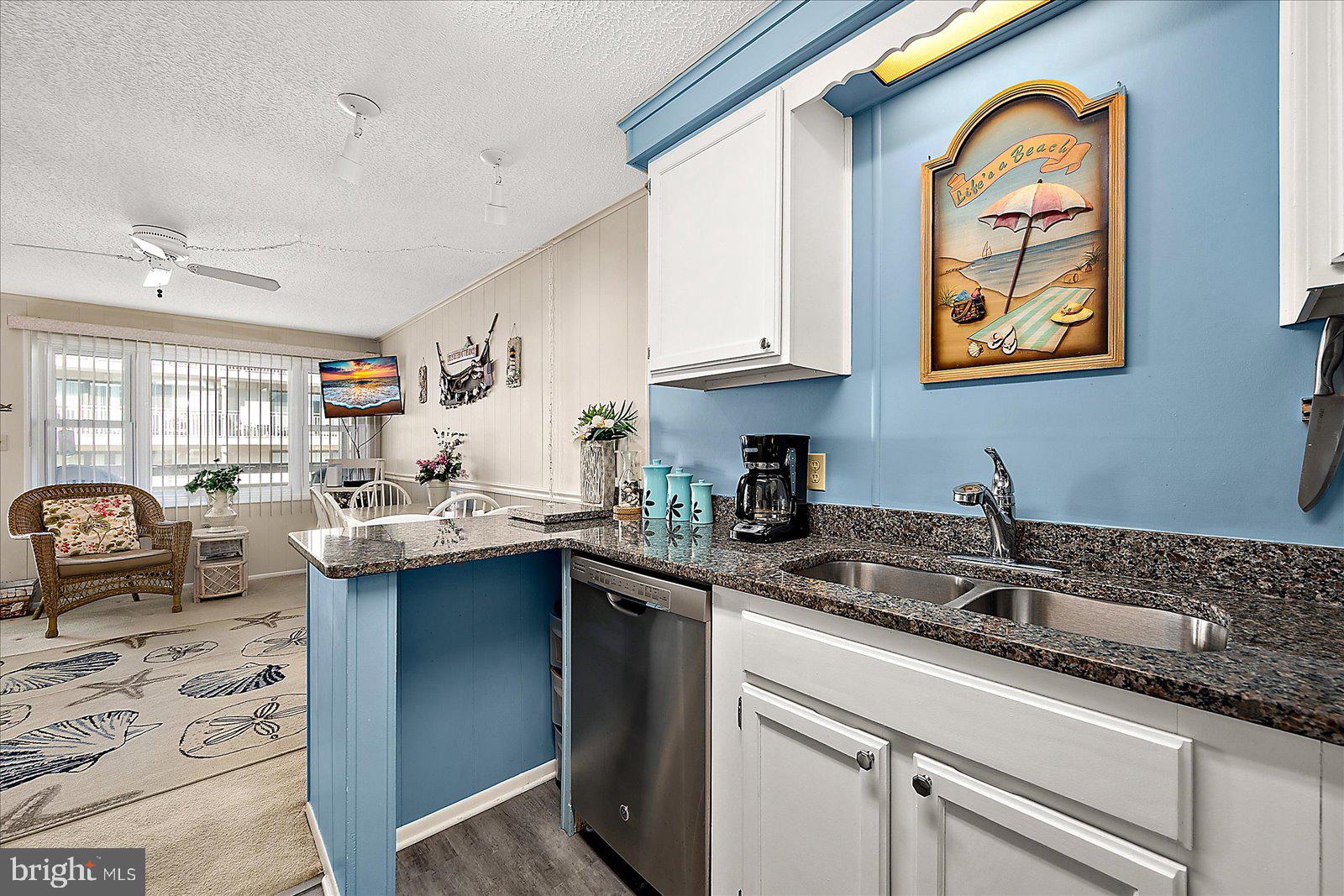 9 46th Street, Unit 22 Ocean City, MD 21842 - Photo 15 of 43 a kitchen with stainless steel appliances granite countertop a sink a stove cabinets and living room view