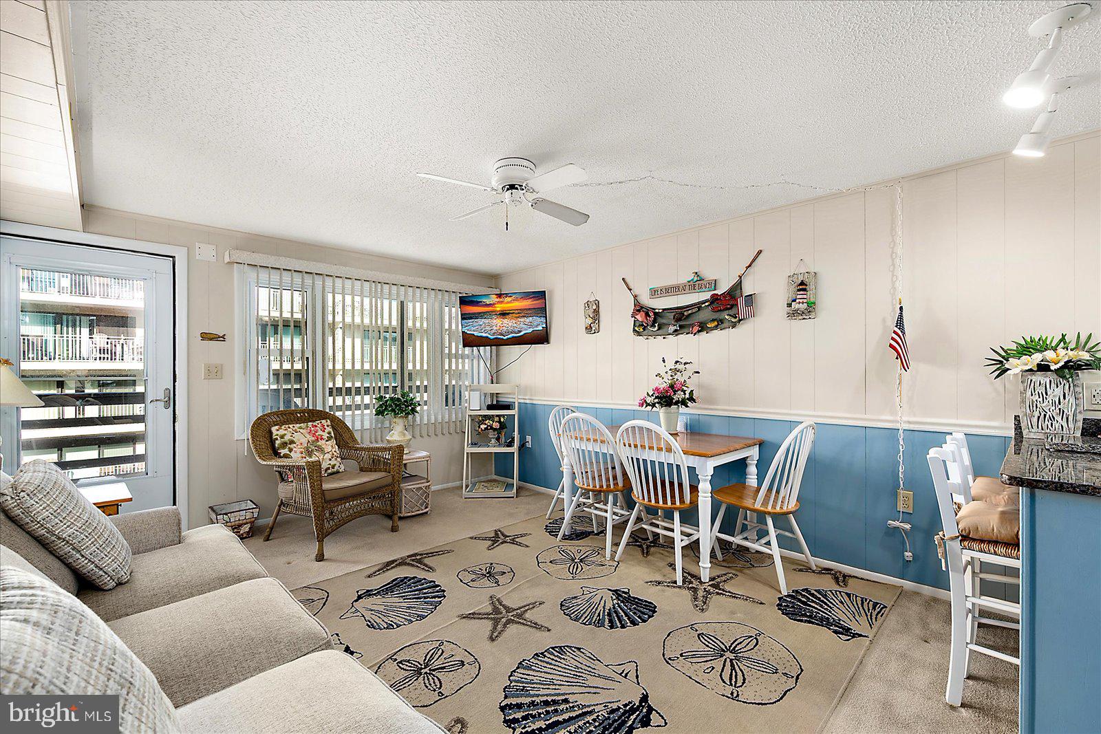 9 46th Street, Unit 22 Ocean City, MD 21842 - Photo 9 of 43 a living room with furniture a chandelier and a dining table