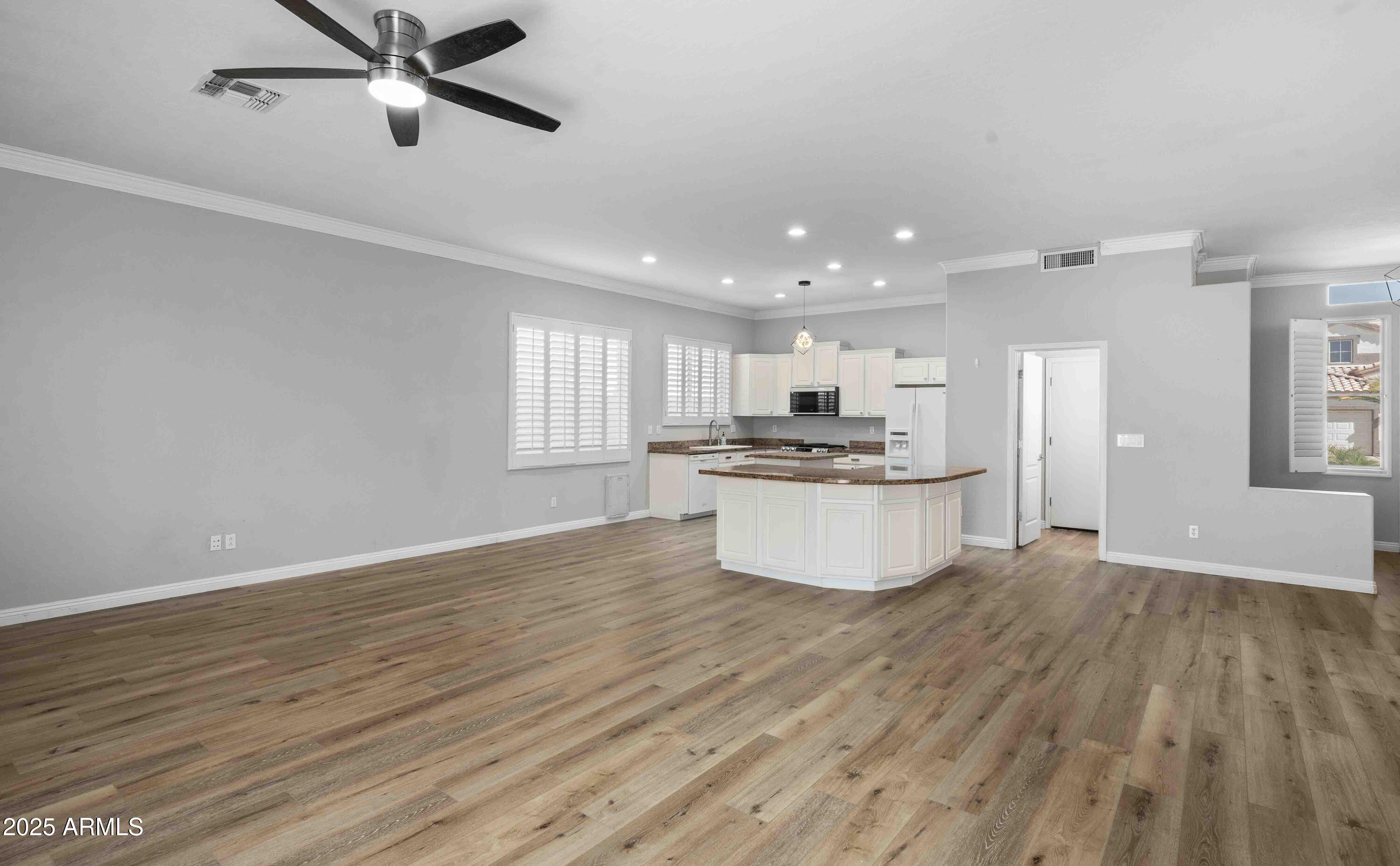 1398 West Windhaven Avenue Gilbert, AZ 85233 - Photo 17 of 58 a large kitchen with cabinets wooden floor and stainless steel appliances